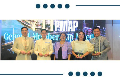 Five award recipients posing on stage with glass trophies during an awards ceremony, with a blue-lit backdrop behind them.