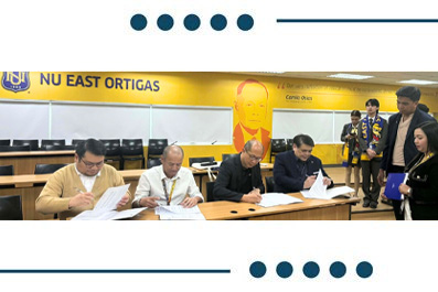 Five men sit at a conference table signing documents during a formal ceremony, with a bright yellow banner behind them.