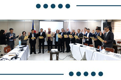 Group of professionals in a conference room standing in a line, each holding a yellow certificate during a formal certificate presentation ceremony.