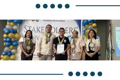 Group of students and teachers on stage at a National High School event, wearing leis and medals, posing with a certificate.