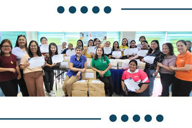Group of students in a classroom proudly holding certificates with stacked boxes in front, celebrating an achievement.
