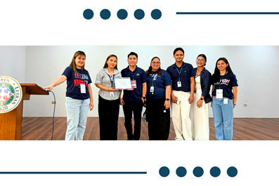 Eight people stand on a stage posing with a certificate during an award ceremony, with a podium to the left and lanyards visible.