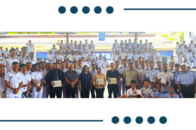 Group photo of students and staff outdoors, with several people in front holding certificates.