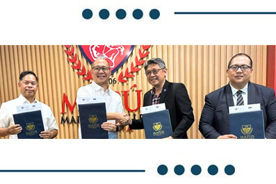 Four men in business attire stand side by side, each holding a blue folder, at a formal ceremony with a carved wooden backdrop and crest emblem behind them.