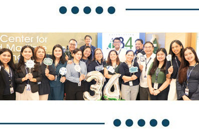 Diverse group of professionals posing for a team photo at a Center for … event, wearing lanyards; a large decorative '36' balloon sits in the center.
