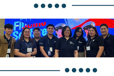 Eight people wearing name badges stand together on a stage with a blue, high-contrast backdrop, posing for a group photo.