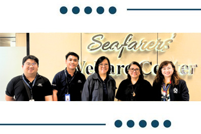 Five staff members pose for a photo in front of a Seafarers Welcome Center sign.