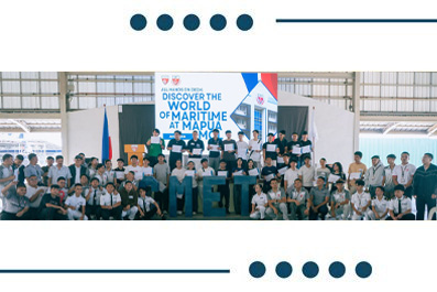 Group photo of students and organizers posing on a stage at a maritime exhibition booth, with a banner in the background reading 'Discover the World of Maritime'
