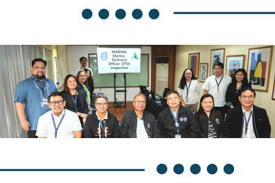 Group of professionals in a conference room posing for a photo, with a presentation screen in the background.