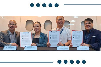 Five professionals in business attire pose with signed documents at a formal signing ceremony.